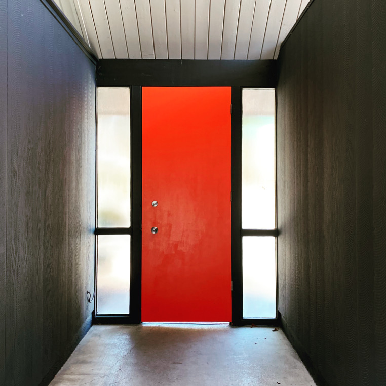 Atrium entry of an Eichler home with a bright red front door