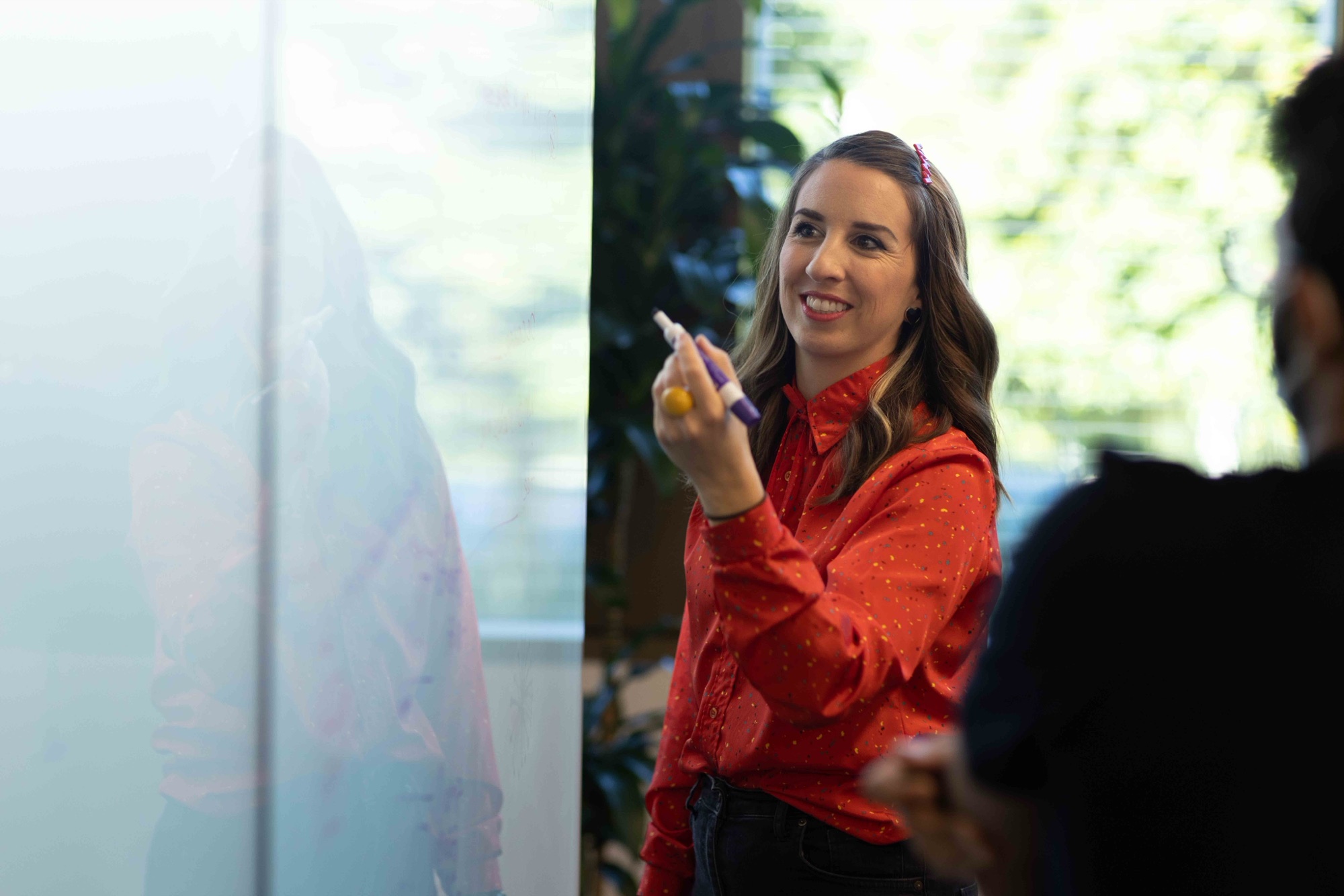 Shawna Kirby sketching ideas on a whiteboard with her team
